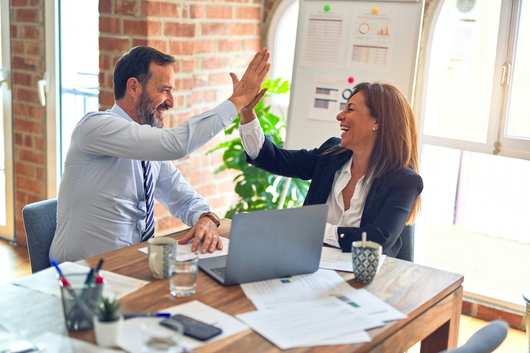 Two recruitment professionals celebrating a successful hire